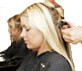 Mane Headlines Hair Salon applying blond hair extensions.